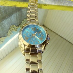 Gold tone teal face watch